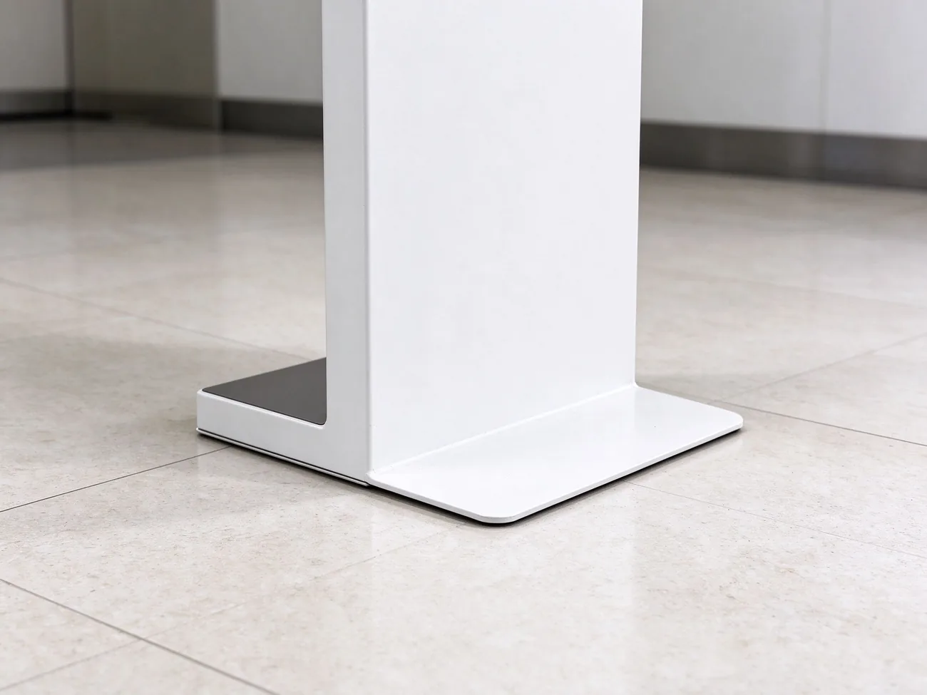 Thin flat low base plate of floor-standing queue kiosk